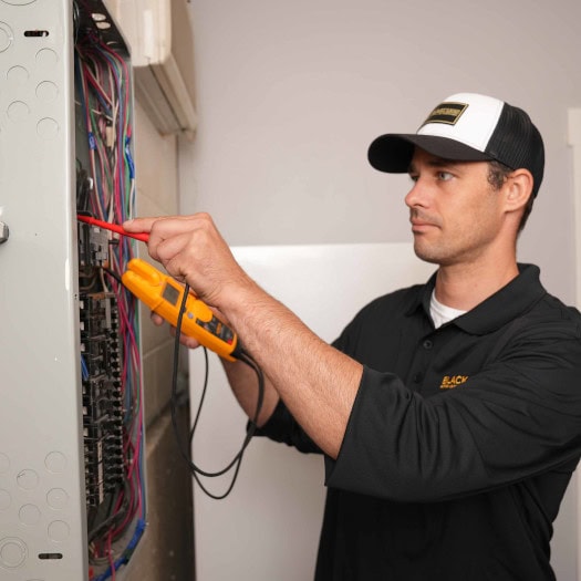 Black Lion HVAC technician working on home surge protection.