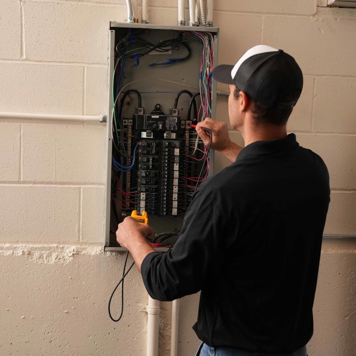 Black Lion HVAC technician working on circuit breaker installation.