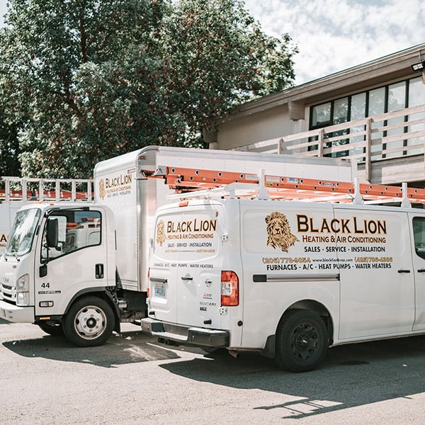 Black Lion HVAC branded trucks outside of warehouse.