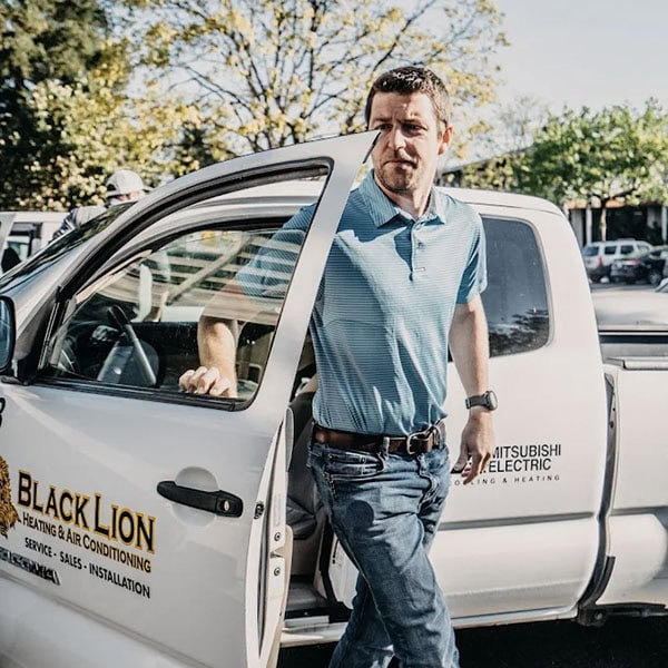 Black Lion HVAC technician getting out of company truck.