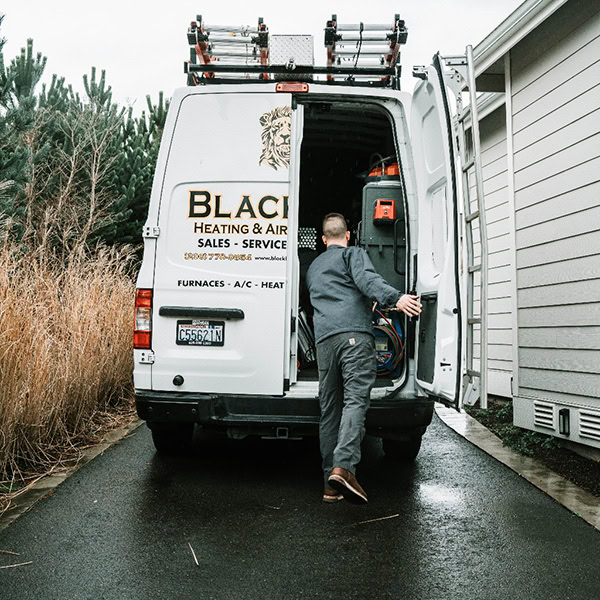 HVAC Technician looking through work van.