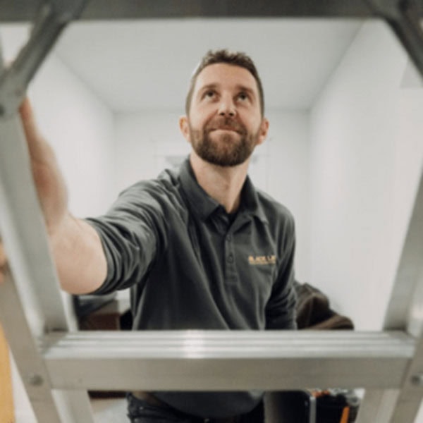 Do I Need an Electrician for Ceiling Fan Installation? An electrician getting ready to install a ceiling fan.