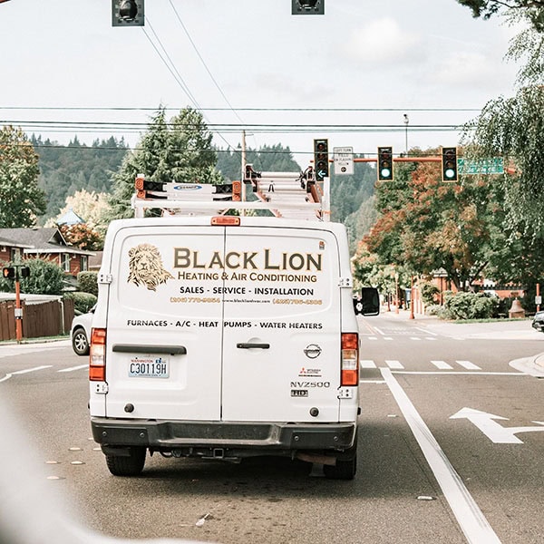 Black Lion Heating, Air Conditioning, & Electrical company truck driving.
