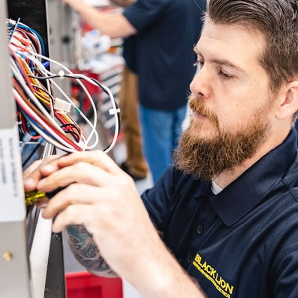 Black Lion Heating, Air Conditioning, & Electrical technician repairing a gas furnace.