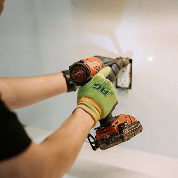 Black Lion Heating, Air Conditioning, & Electrical technician installing an electrical outlet.