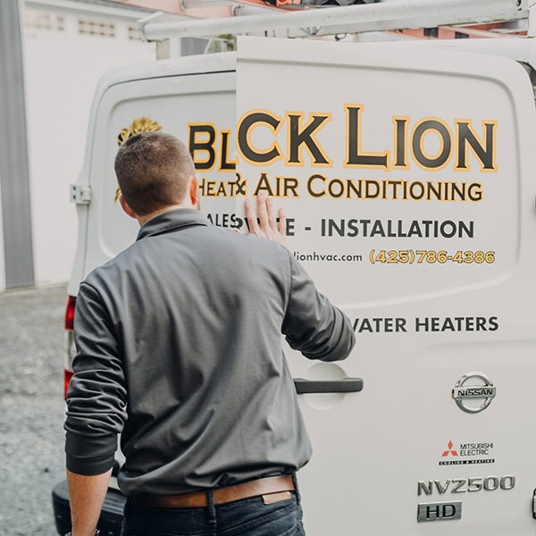 Black Lion Heating, Air Conditioning, & Electrical technician closing the back door of the company truck.